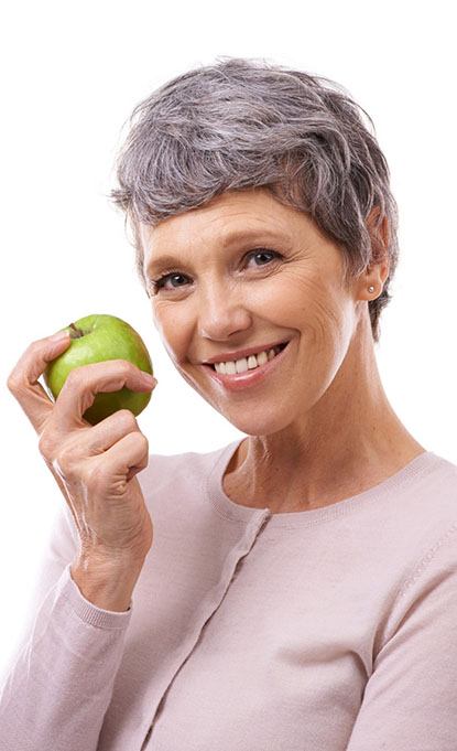 smiling woman holding a green apple 