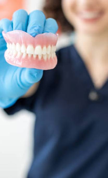 Lab technician holding a set of dentures