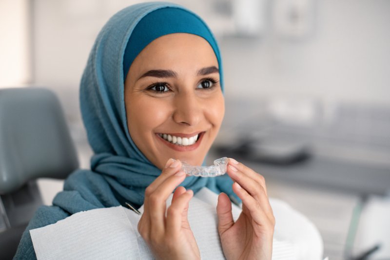 Patient holding their Invisalign aligner